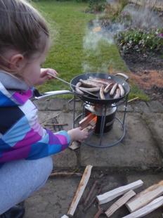 child with sausage on stove