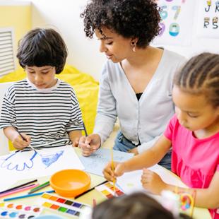 Tutor and young children painting together
