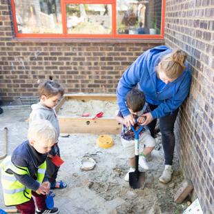 A person and children digging outdoors.