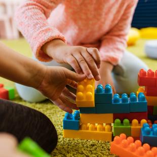 Children playing with colourful plastic building blocks