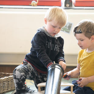 Two children playing with a tube
