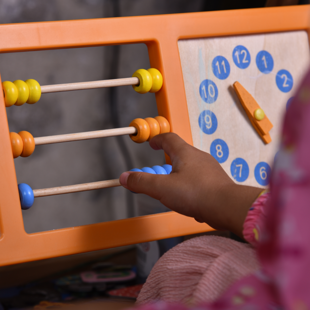 child playing with colourful abacus counting frame