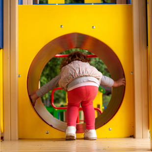 child crawling through the tunnel in the playground
