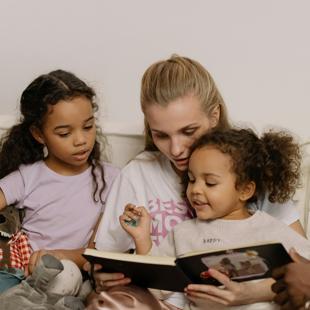 A person reading a book with children
