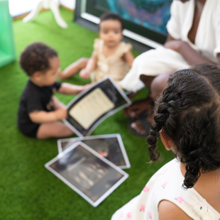 group of babies and young children exploring learning materials with an adult