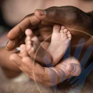 baby feet being held by two pairs of hands