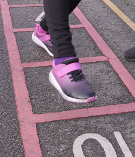 child's feet playing hopscotch