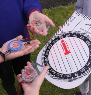 children's hands with compasses