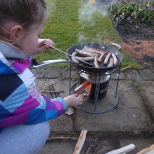 child with sausage on stove